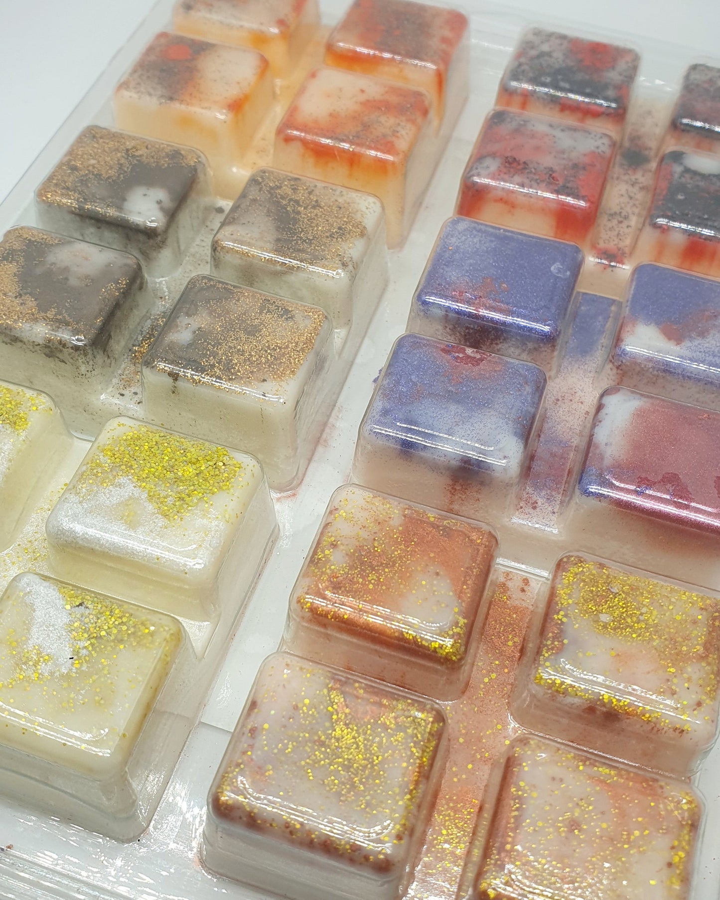 Assorted square soap bars in various colors on a white background