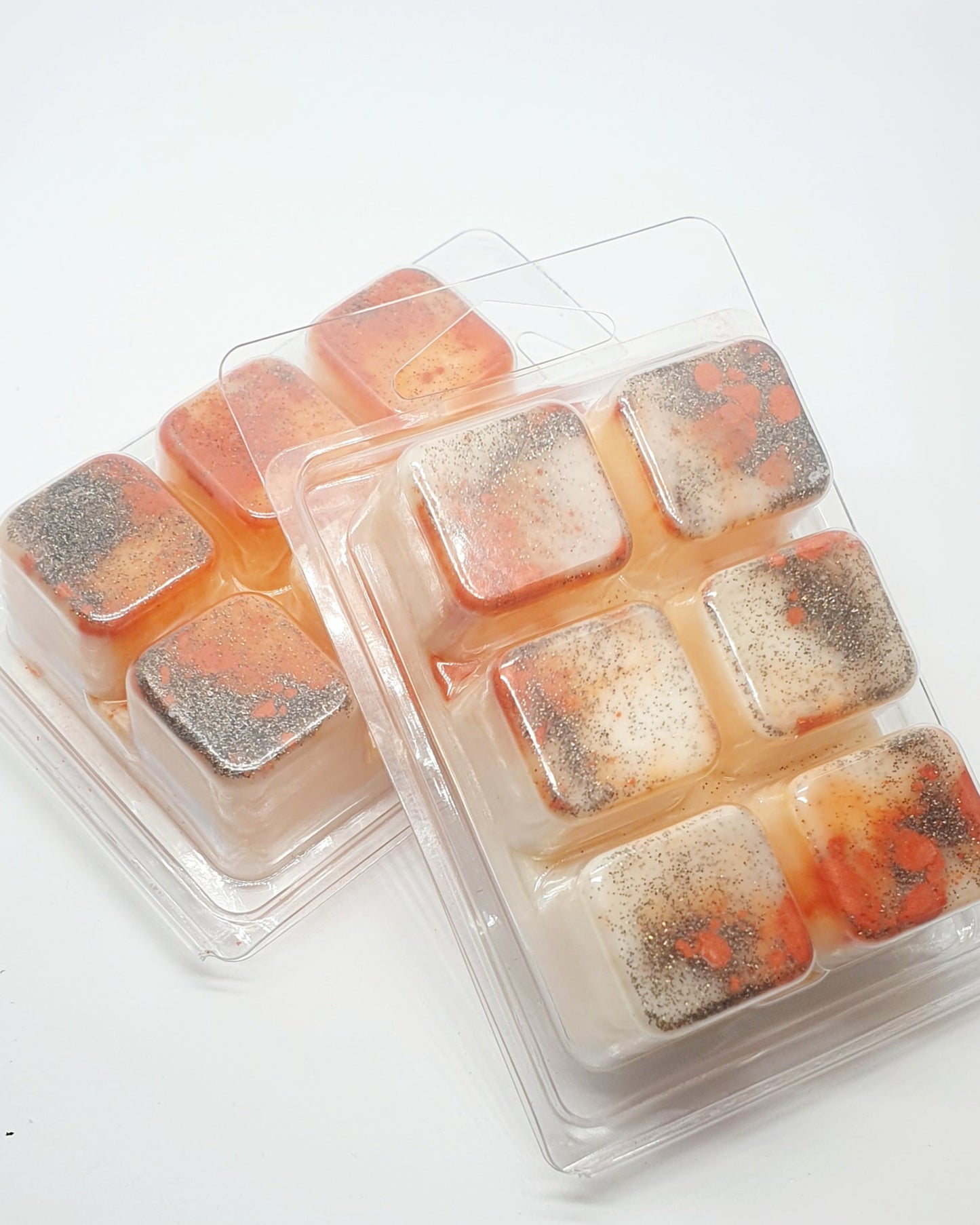 Packaged wax melts with gradient colors on a white background
