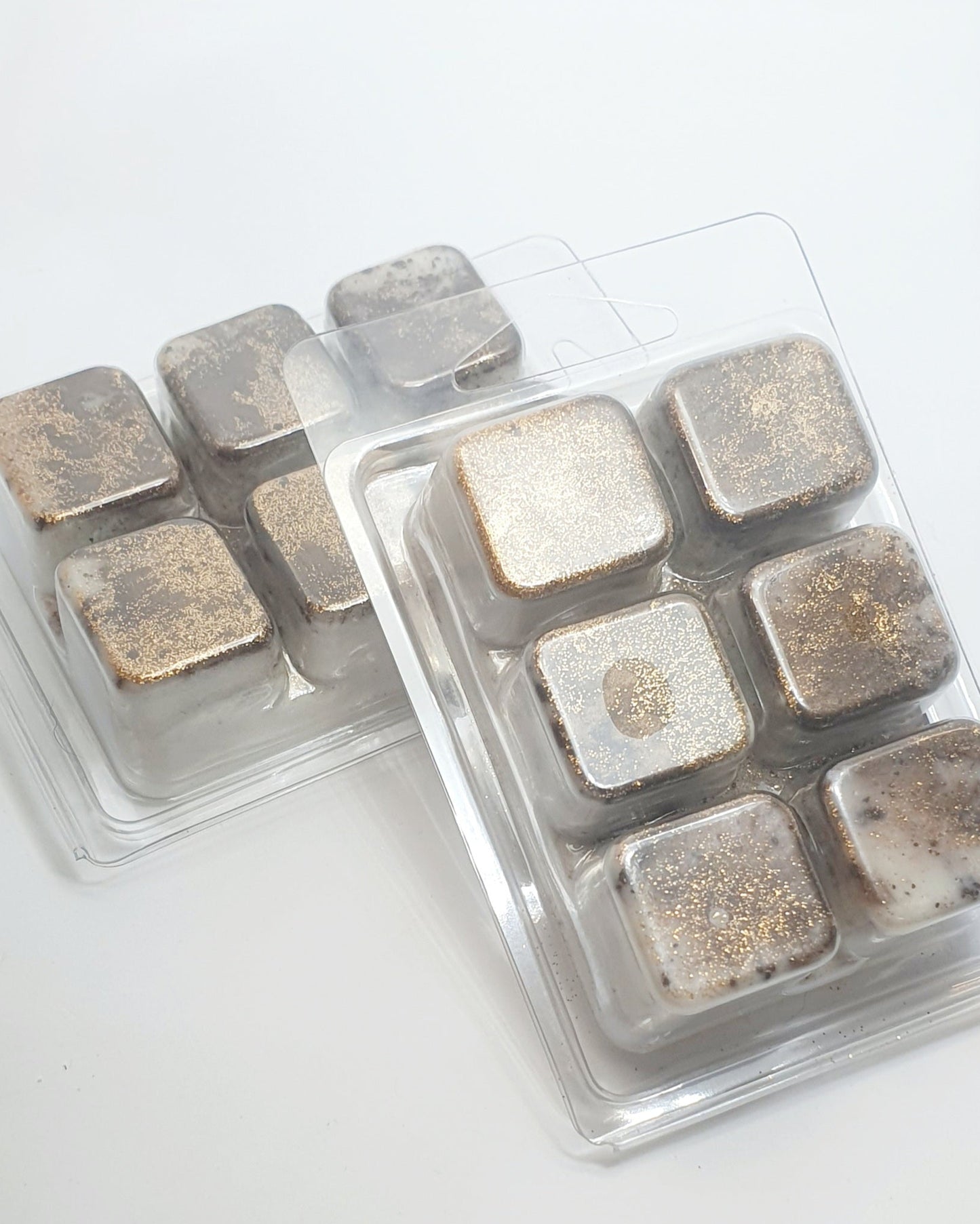 Packaged square wax melts with metallic finish on a white background