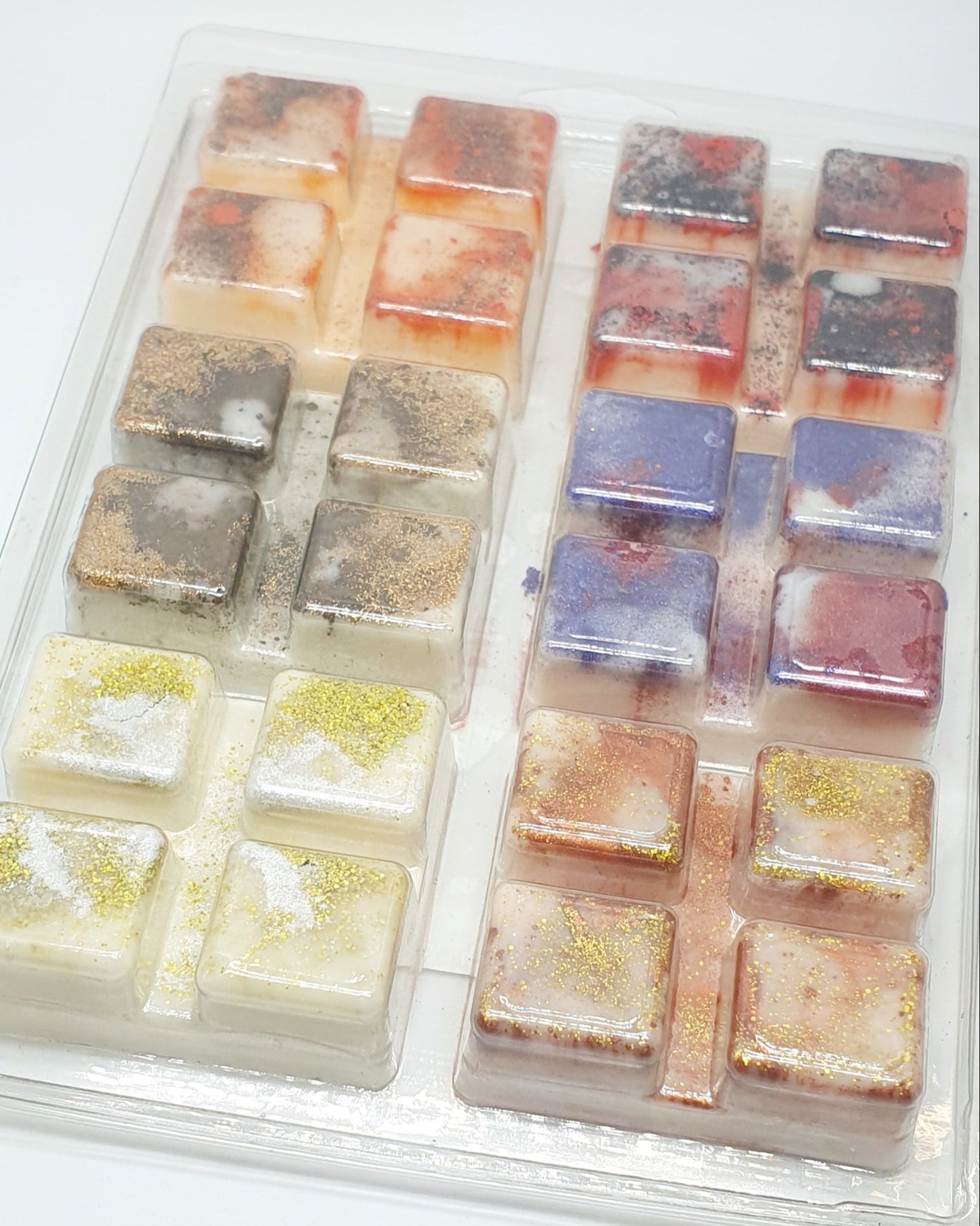 Set of colorful wax melts in a clear plastic container on a white background