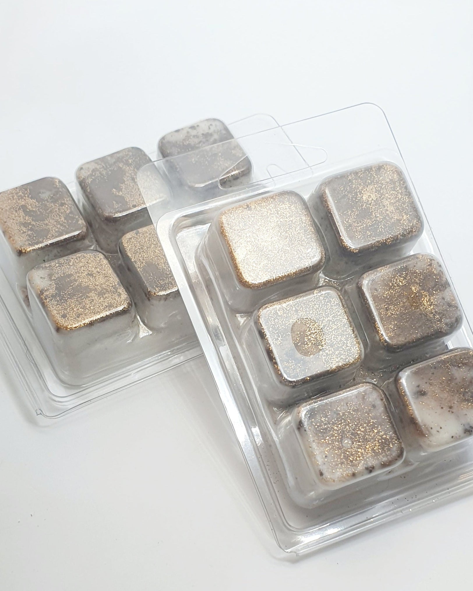 Packaged square wax melts with metallic finish on a white background