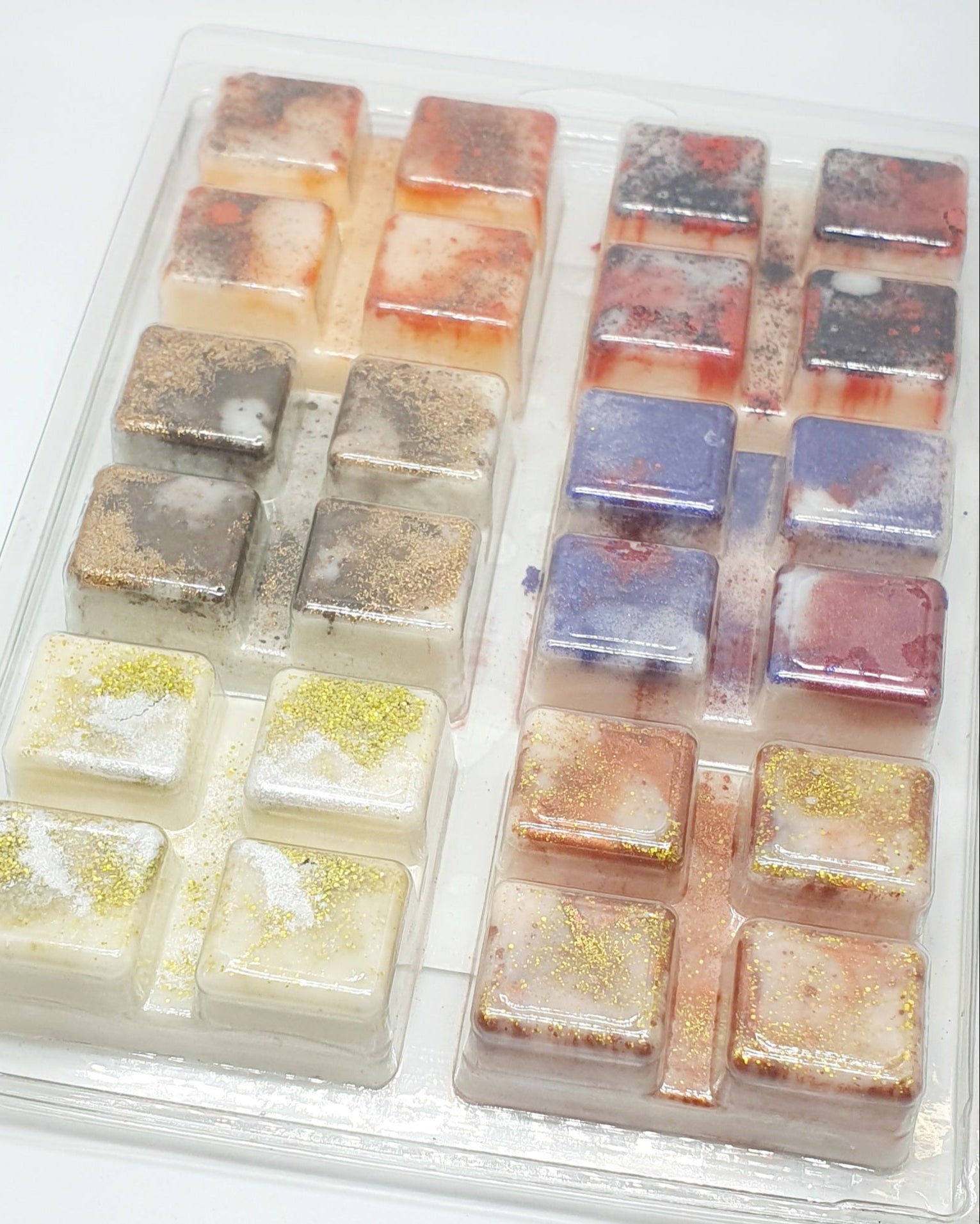 Set of colorful wax melts in a clear plastic container on a white background